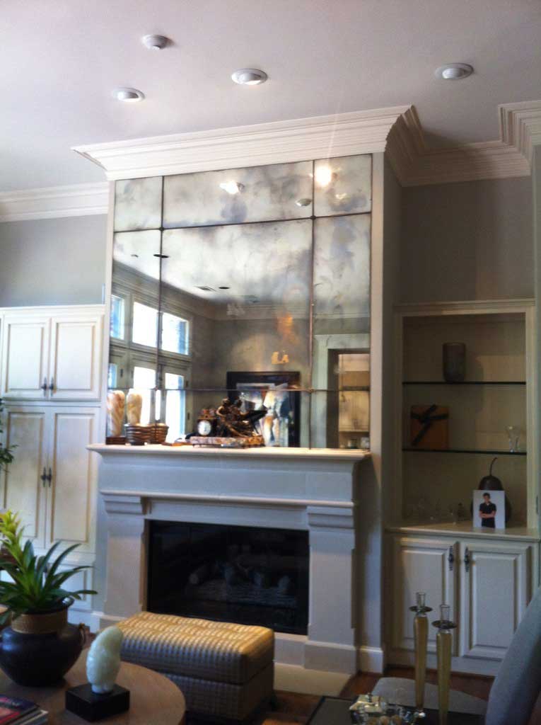 Decorative antique mirror glass above fireplace mantel