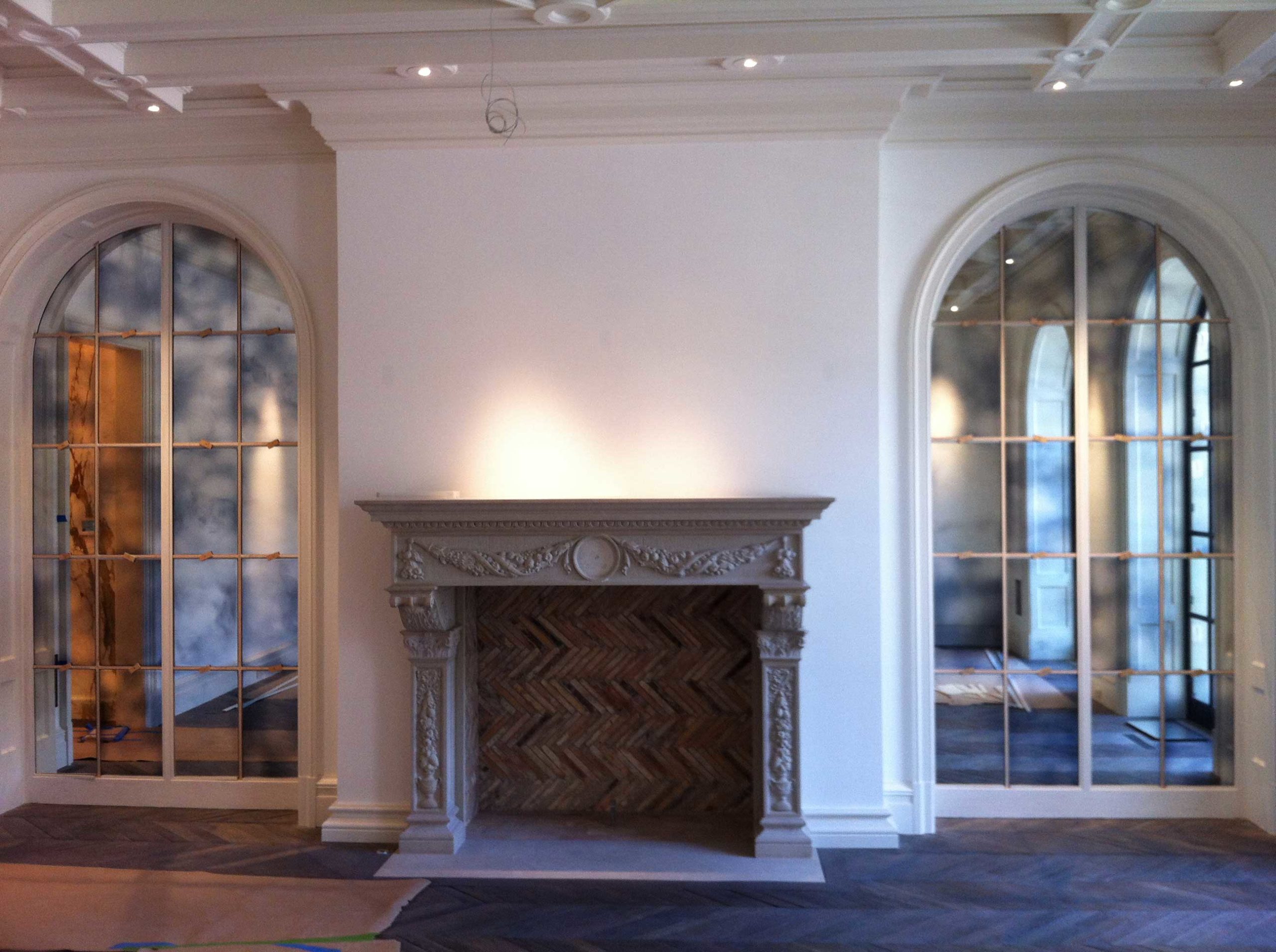 Decorative antique glass mirrors on each side of fireplace